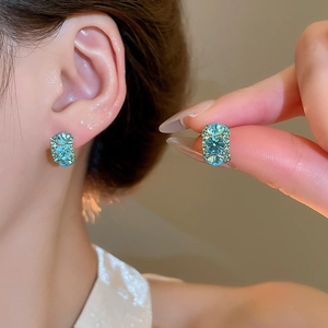 Macro detail of square zircon pearl earrings with 18k gold plating and blue crystals