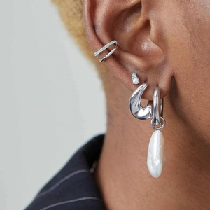 Dettaglio orecchini in argento con pendente in perla barocca e ear cuff con strass