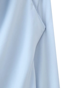 Detailed close-up of light blue satin fabric showing fine stitching and pocket edge detail