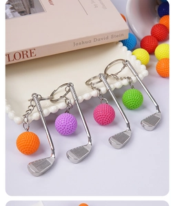 Detailed shot of mini golf club keychains in four colors on a white pearl tray