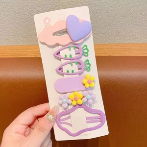 Détail de barrettes à cheveux en résine aux couleurs pastel avec nuages et carottes