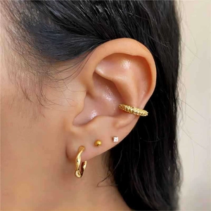 Close-up of 18k gold plated Mobius twisted hoop and stacked minimalist stud earrings