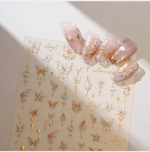 Detail of pink butterfly nail stickers with gold outlines and soft floral gradients