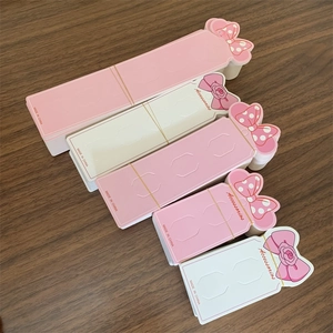 Close-up of pink and white paper display cards for hair clips in various sizes