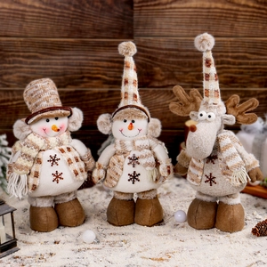 Tre statuette natalizie di peluche con pupazzo di neve e alce con ricami su sfondo di legno