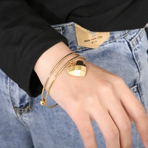 Macro shot of double-layer gold stainless steel bracelet with geometric heart charm