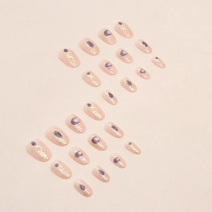 Short oval press-on nails featuring gold foil star-moon patterns and purple glitter accents