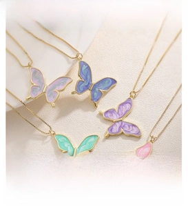 Detail view of five gradient butterfly pendants with enamel wings on gold-plated chains
