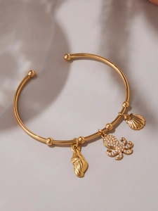 Detail of gold-plated ocean bangle with crystal octopus and delicate shell charms