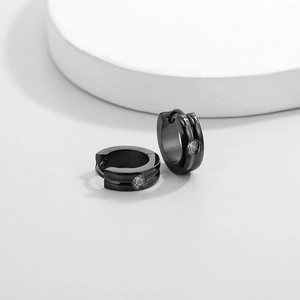 Close-up of black stainless steel hoop earrings featuring a single inlaid white zircon stone