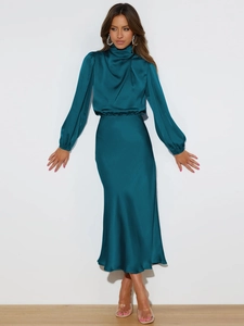 Detail of high-gloss teal satin fabric showing the elegant sheen and waist tailoring