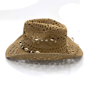 Brown hand-woven cowboy straw hat with boho bead and shell decorations on white background
