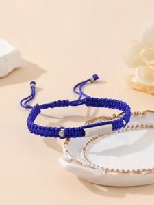 Detail of blue braided stainless steel bracelet on elegant ceramic plate with petals