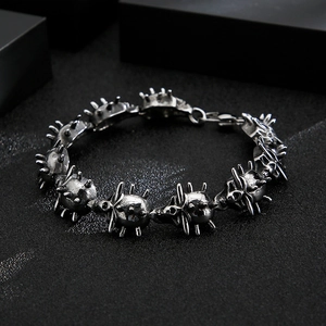 Detailed close-up of punk skull bracelet with spikes in distressed silver steel finish