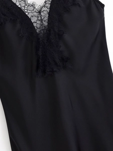 Dettaglio dell'elegante tessuto in raso nero con rifiniture in pizzo sul decolleté