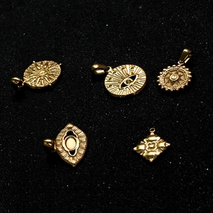 Flat lay of multiple 18k gold plated evil eye charms and DIY jewelry pendants