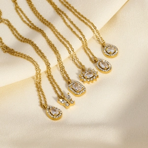 Détail de six colliers dorés avec pendentifs en zircon sur un élégant satin beige