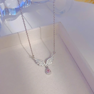 Silver angel wing necklace featuring a pink teardrop zircon pendant on jewelry box