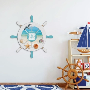 Detail of wooden ship wheel wall decor with 3D shells, starfish, and seagull accents