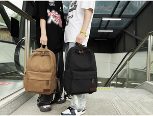 Lifestyle shot of casual canvas backpacks in khaki and black with leather zipper details