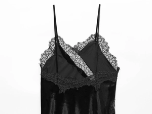 Gros plan sur une robe en satin noir avec bordure en dentelle et fines bretelles