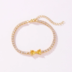 Detail view of gold-plated tennis bracelet with yellow heart-shaped zircons