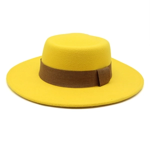 Detail of a bright yellow wool felt boater hat with a contrasting brown fabric band