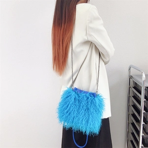 Detail view of the blue faux fur bucket bag with silver chain strap and drawstring closure