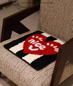 Macro detail of the plush tufted texture and red heart design on the square chair cushion