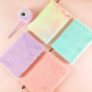 Dettaglio di quaderni in peluche in viola e arcobaleno con penna pelosa coordinata