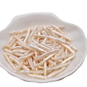 Natural Baroque stick pearls displayed in a white shell-shaped ceramic tray