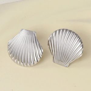Detailed macro view of silver seashell earrings with polished metallic radial textures