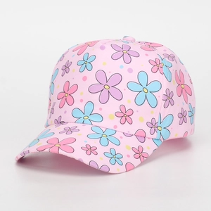 Detail view of the pink baseball cap featuring colorful floral patterns and polka dots