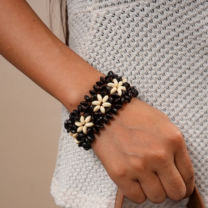Detailed view of bohemian multilayer coconut shell and wood bead bracelet on wrist