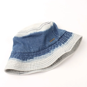 Gros plan détaillé d'un bob en denim dégradé bleu et blanc avec étiquette métallique
