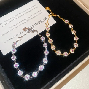 Close-up of gold and silver circular zircon bracelets in a black jewelry box