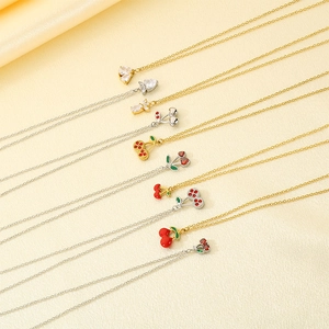 Detailed macro view of strawberry and cherry enamel pendants on stainless steel necklaces