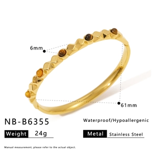 Detail view of gold stainless steel bangle inlaid with brown and amber stones