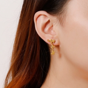 Golden elephant and heartbeat stainless steel stud earrings on model's ear