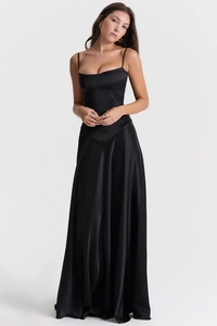 Detail of a sleek black satin dress showing corset-style stitching and silky material