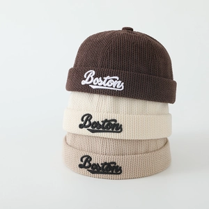 Détail de la broderie Boston sur des bonnets Miki en velours côtelé marron et beige
