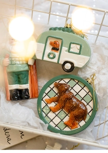 Close-up of ceramic Christmas ornaments featuring Santa and a bear in a white basket