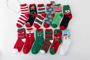 Close-up of 12 pairs of thick coral fleece Christmas socks featuring festive holiday patterns