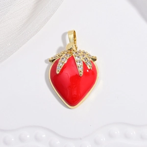Macro shot of red enamel strawberry pendant with gold base and clear zircon leaves