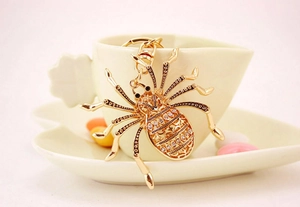 Detailed view of a gold spider keychain with sparkling rhinestones and metal hook