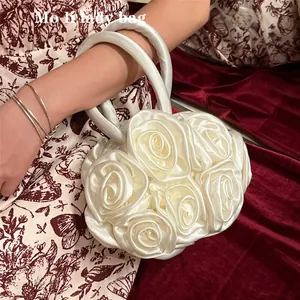 Detailed view of handcrafted white satin rose petal evening bag with round handle