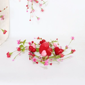 Detail view of heart-shaped candles with floral vine decor for table centerpieces