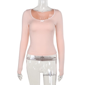 Detail of square neck pink top with lace trim and bow accent on white background