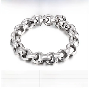 Macro detail of chunky stainless steel D-link chain bracelet with skull charm accent