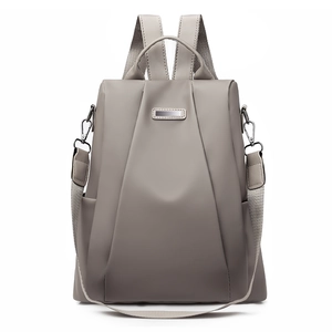 Close-up of beige nylon travel backpack with PU leather straps and metal hardware detail